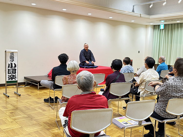 高座で話す三遊亭小圓楽さんと客席の様子