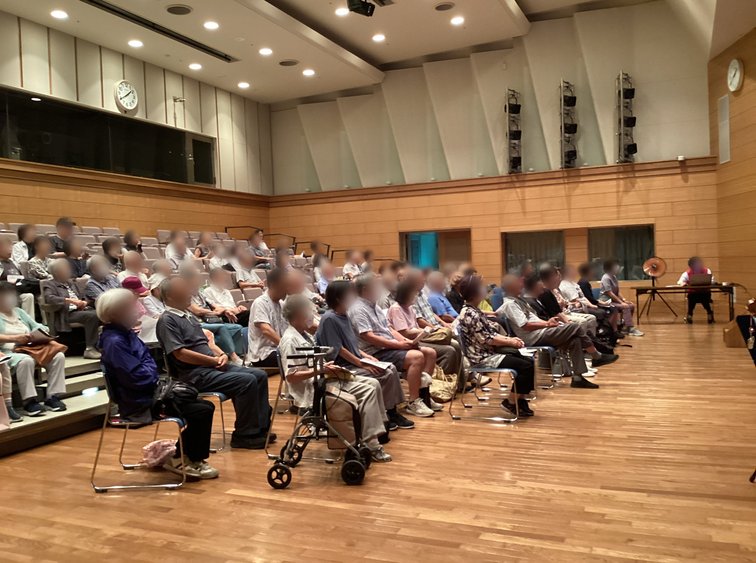 ハーモニーホールの客席で歌う参加者の皆さま